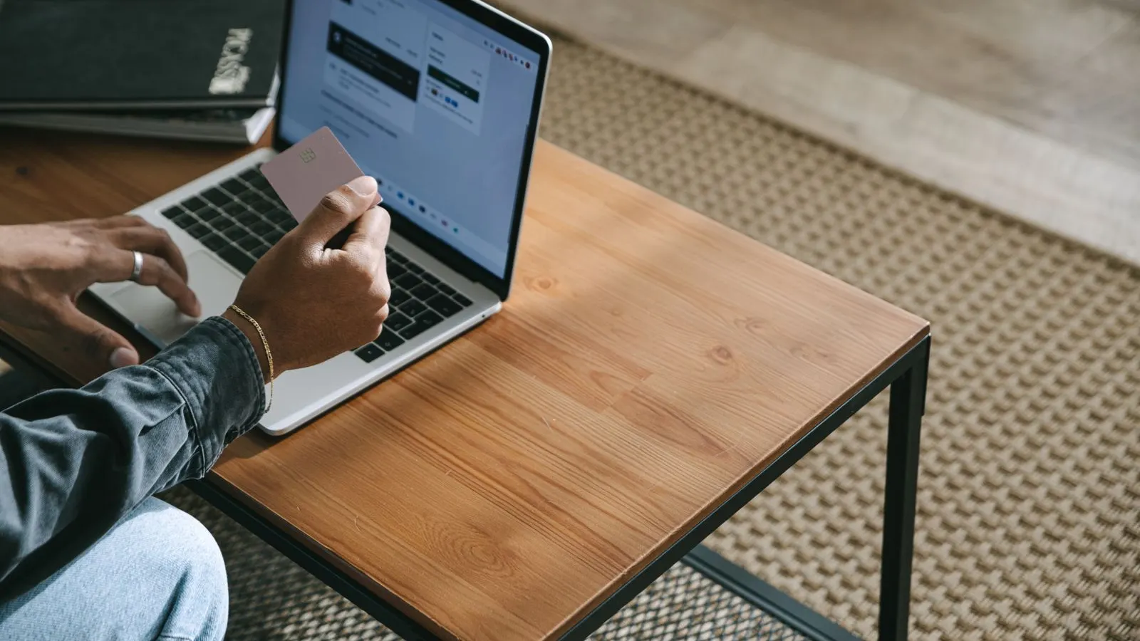 Person holding a credit card at a laptop