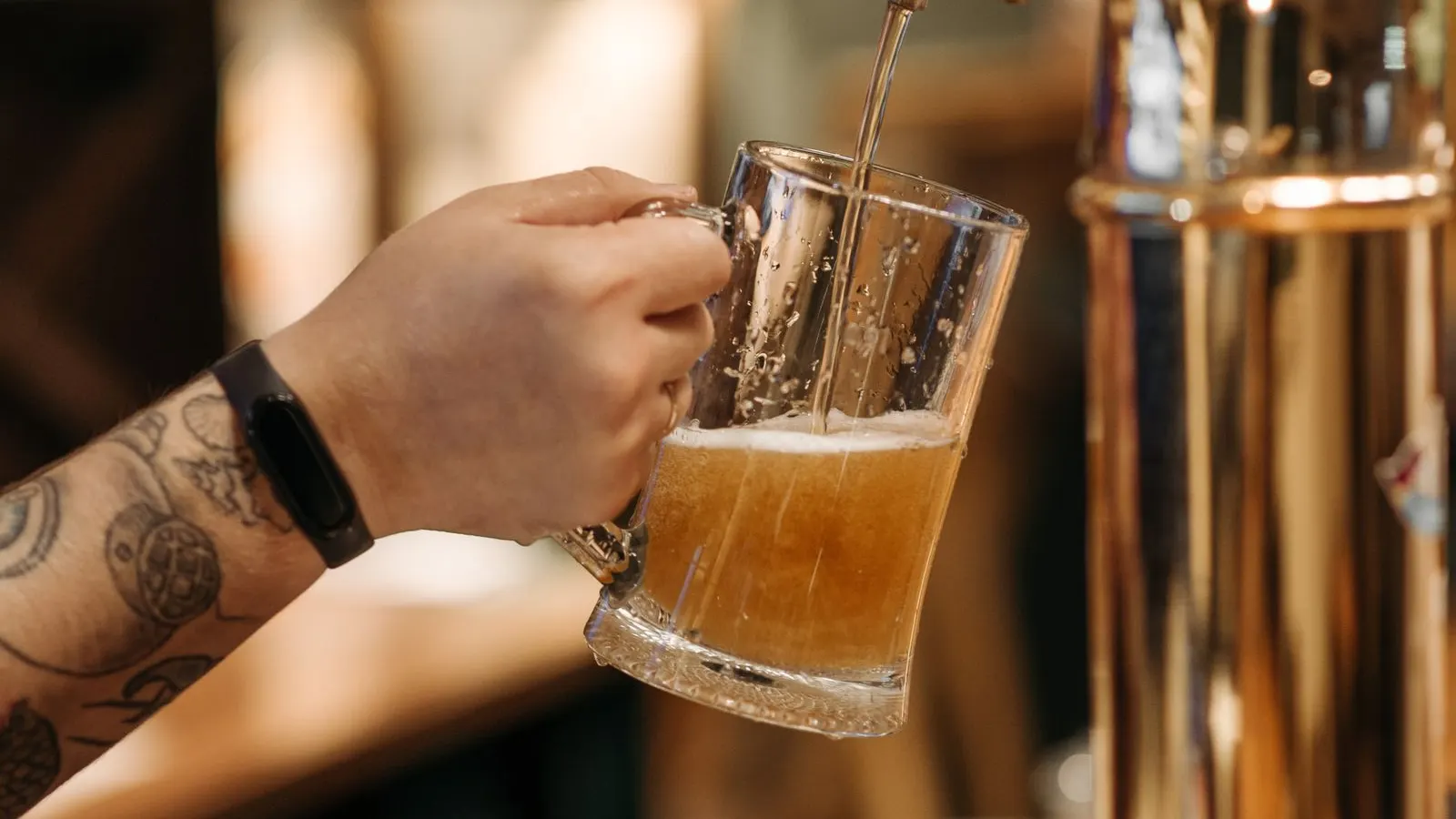Bartender pulling a pint at a busy UK pub bar
