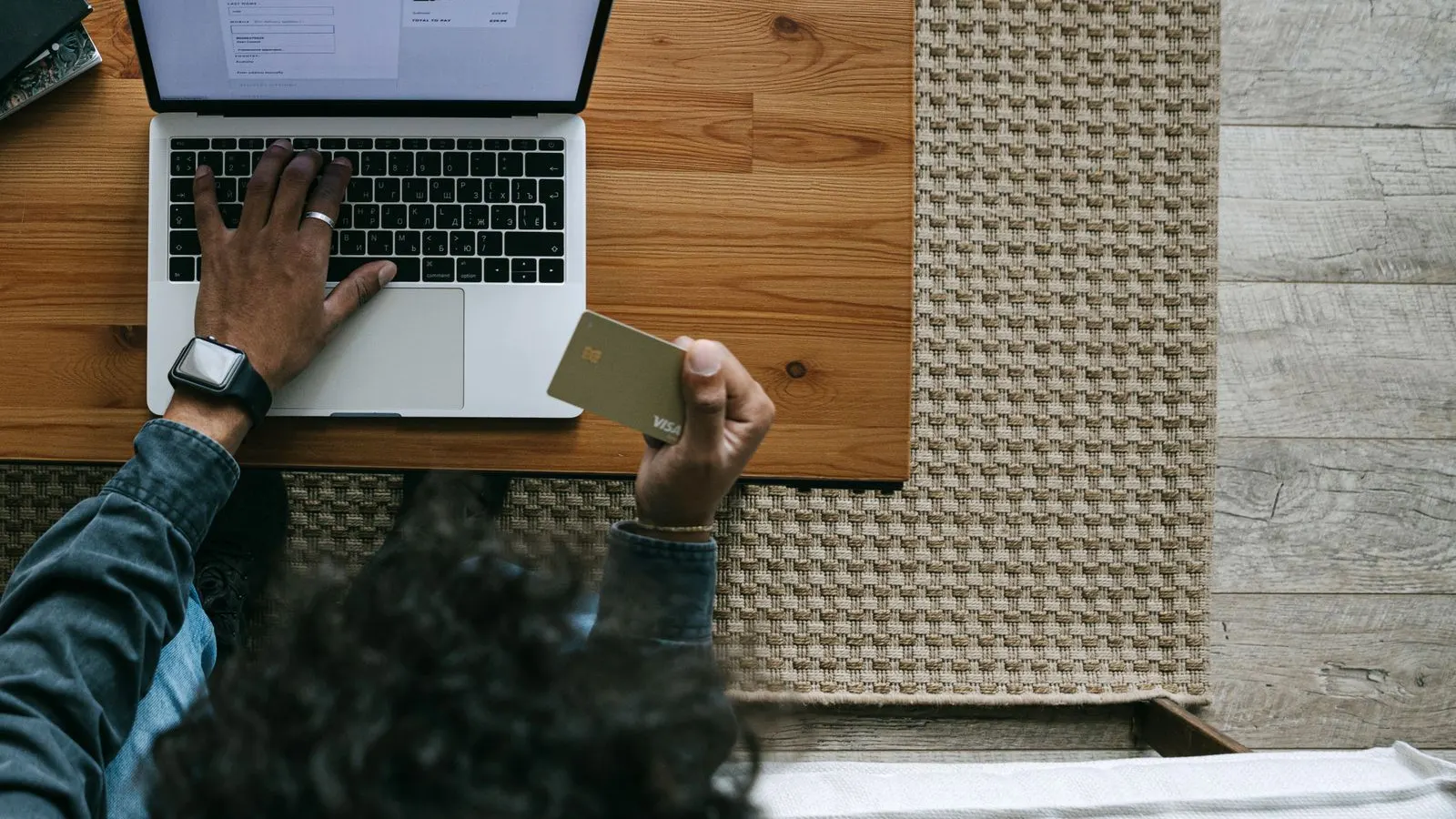 Business owner reviewing finances with a card and laptop