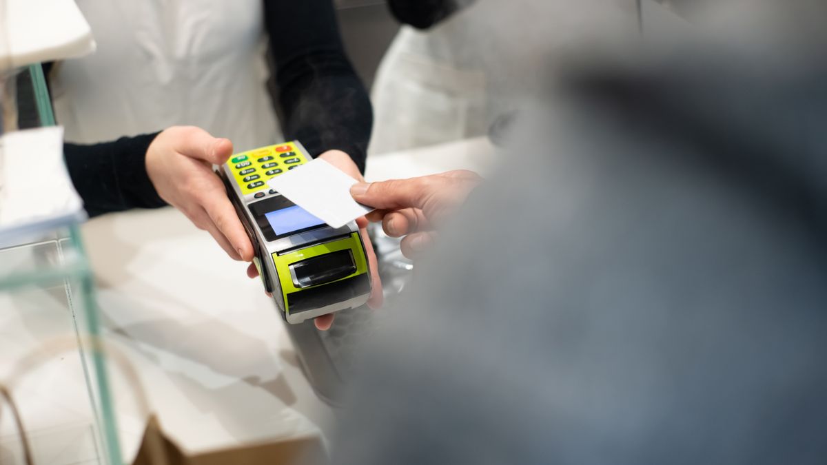 Customer paying by card at a café counter