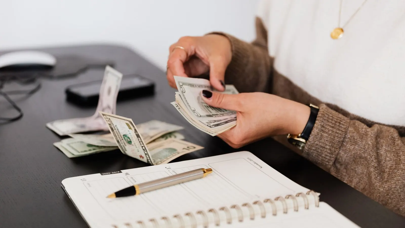 Business owner counting cash takings at a desk