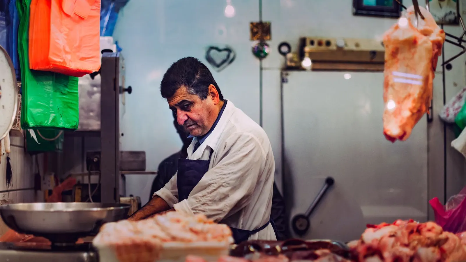 Butcher standing behind a meat display counter