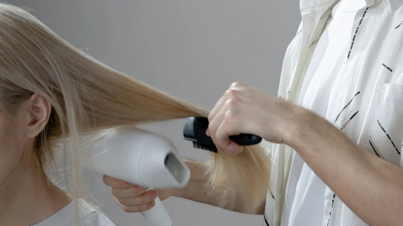 Hairdresser blow-drying a client's hair