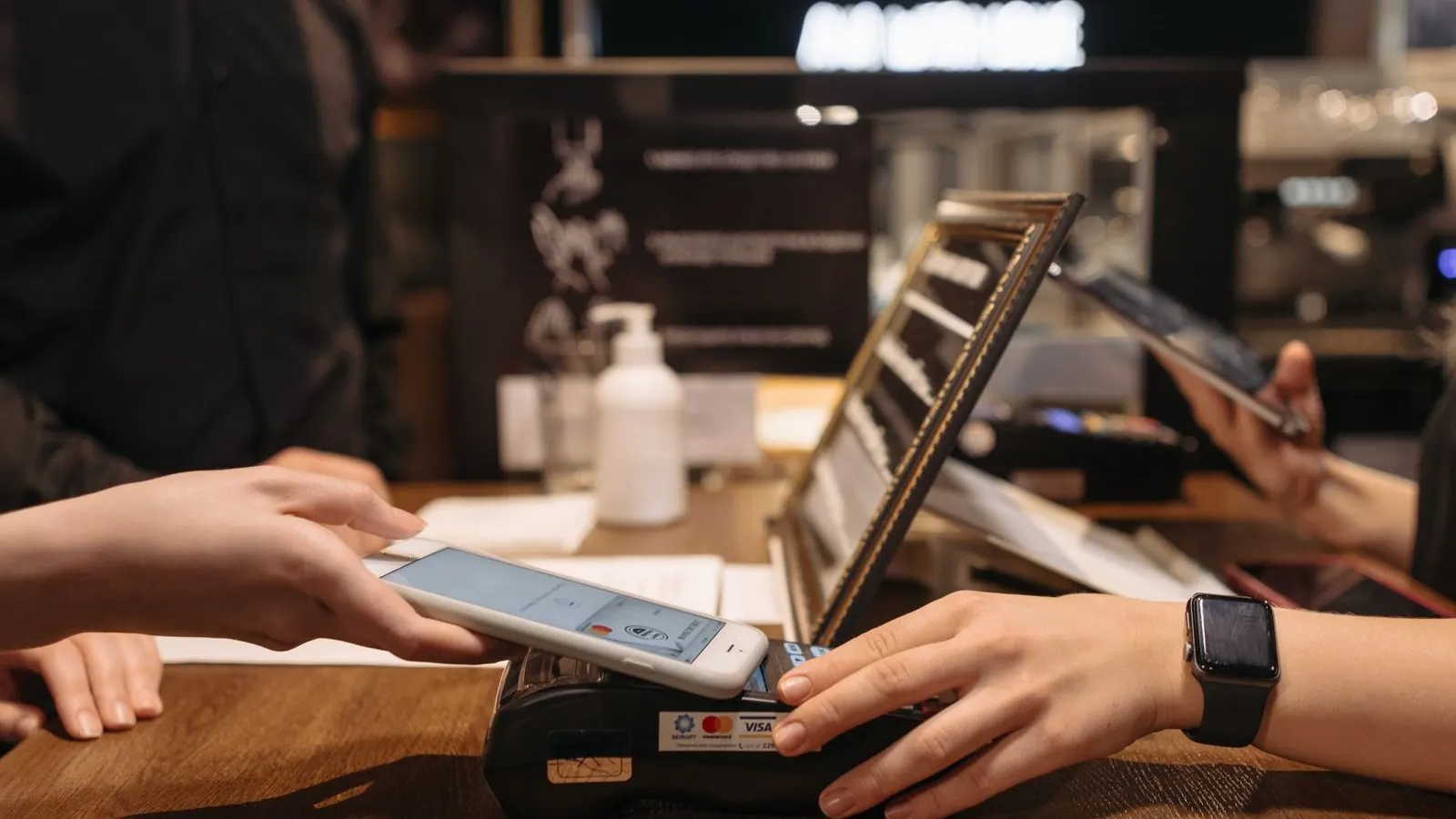 Customer paying by tapping a phone on a card terminal