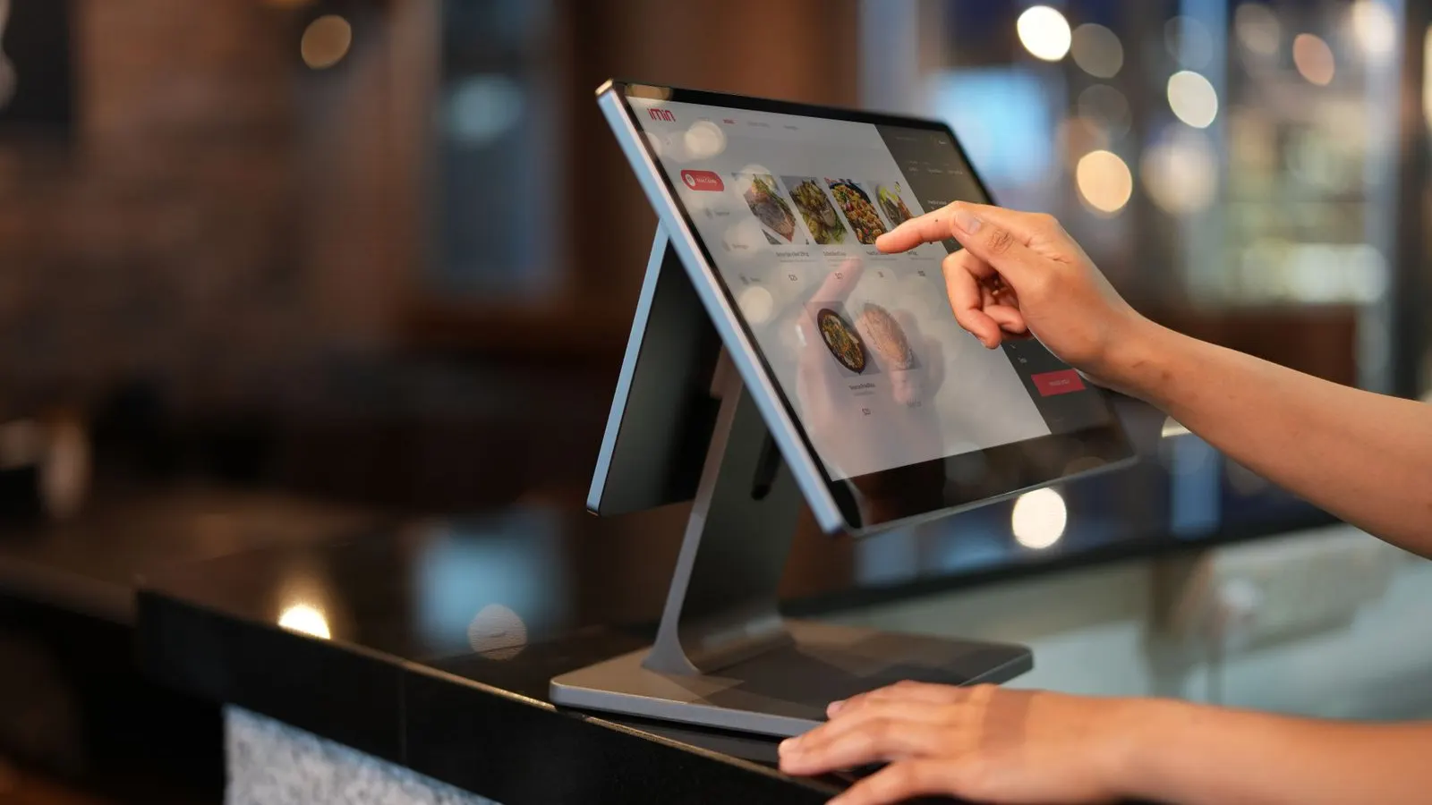 Close-up of a cashier ringing a sale through a point of sale touchscreen