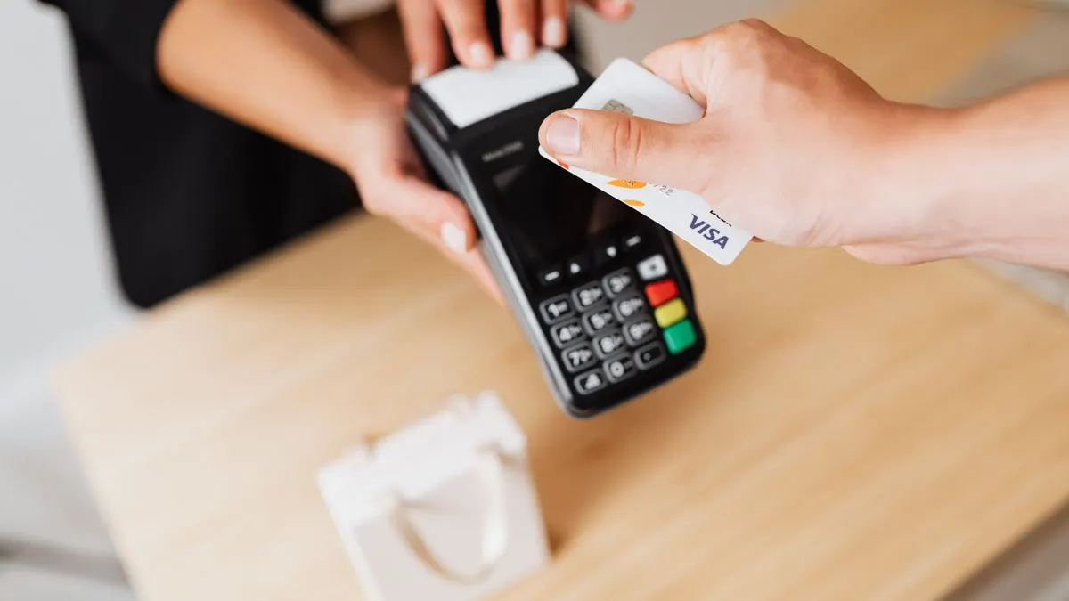 A UK small business owner taking a contactless card payment on a card reader