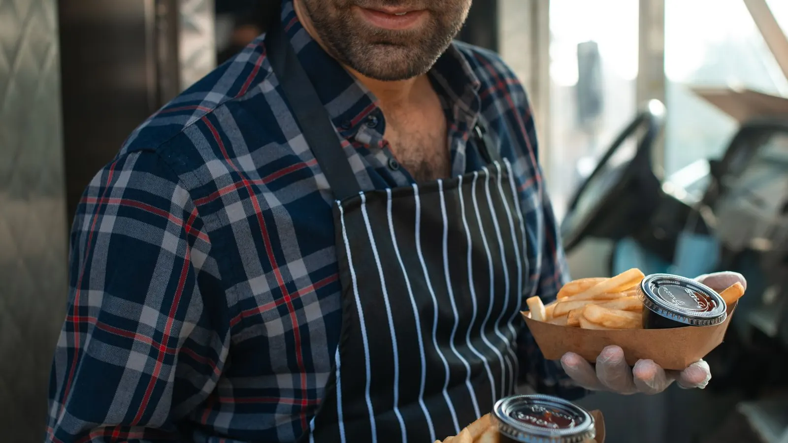 Street food vendor serving orders from a food truck hatch