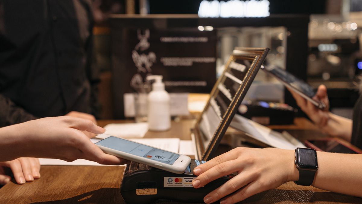 Person tapping a phone on a payment terminal