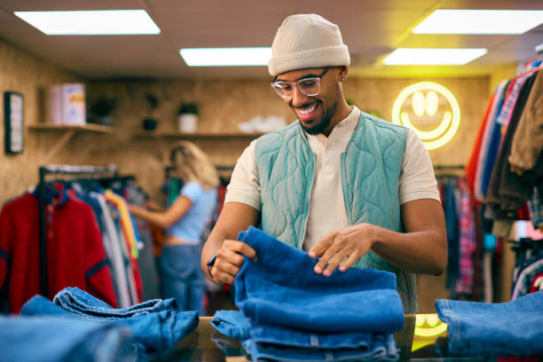 Shop assistant folding clothes in an independent store