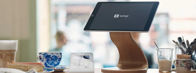 SumUp iPad POS on a wooden stand with an Air card reader on a cafe counter